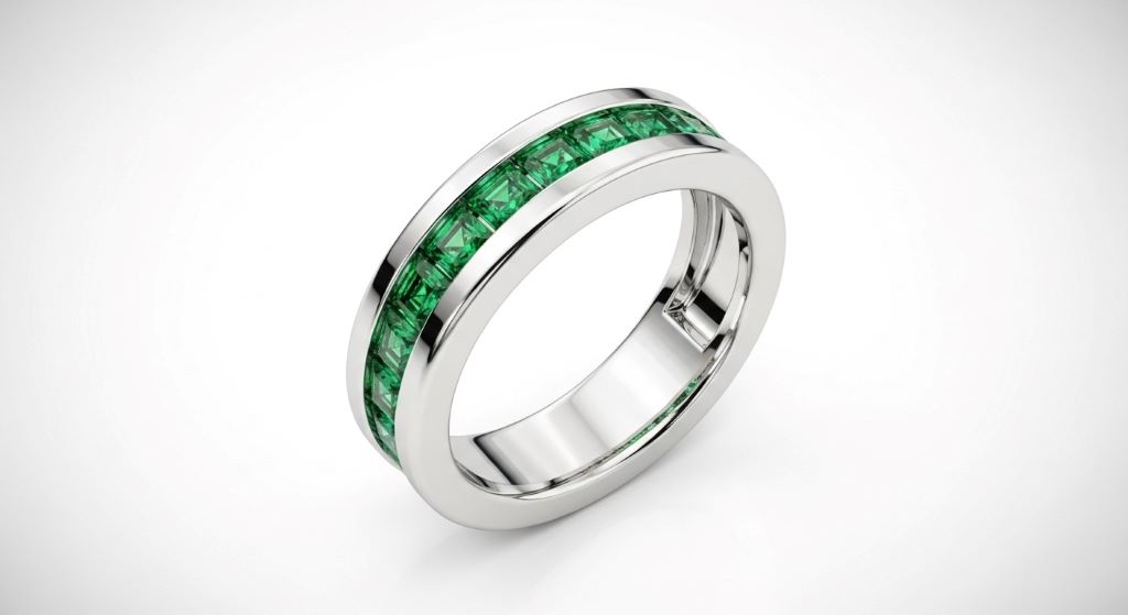 Platinum emerald wedding band with channel-set green emeralds and polished finish on white background